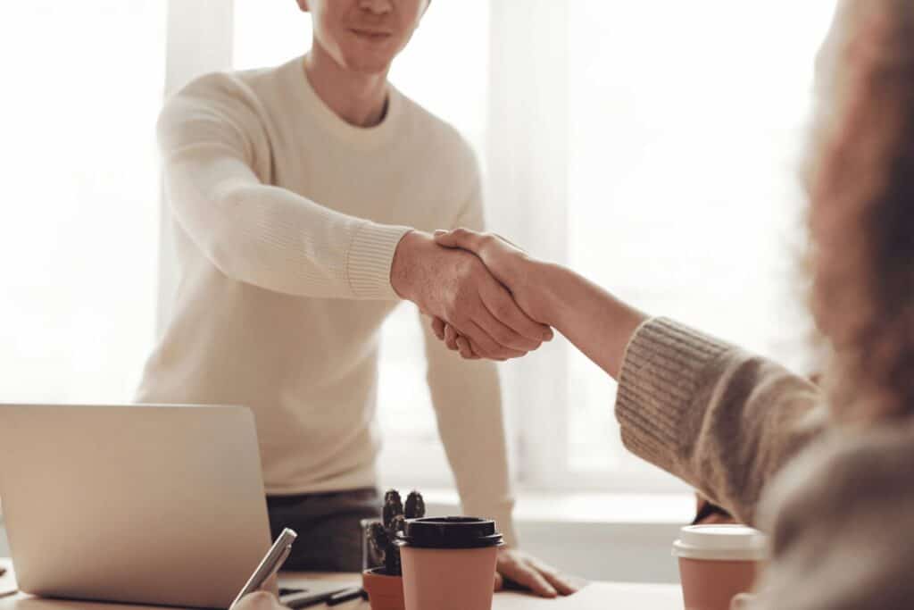 two people shaking hands at a meeting